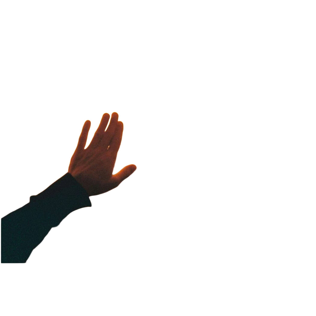 A hand pressed against a fogged-up window, fingers spread as if reaching out through the warm, golden haze.