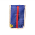 Blue checkered fabric pouch with a red vertical strap and cream-colored stitched edges, featuring a small yellow sun logo tag.