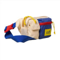 A colorful, patchwork-style waist bag with a blue grid-patterned section and cream-colored fabric panels.