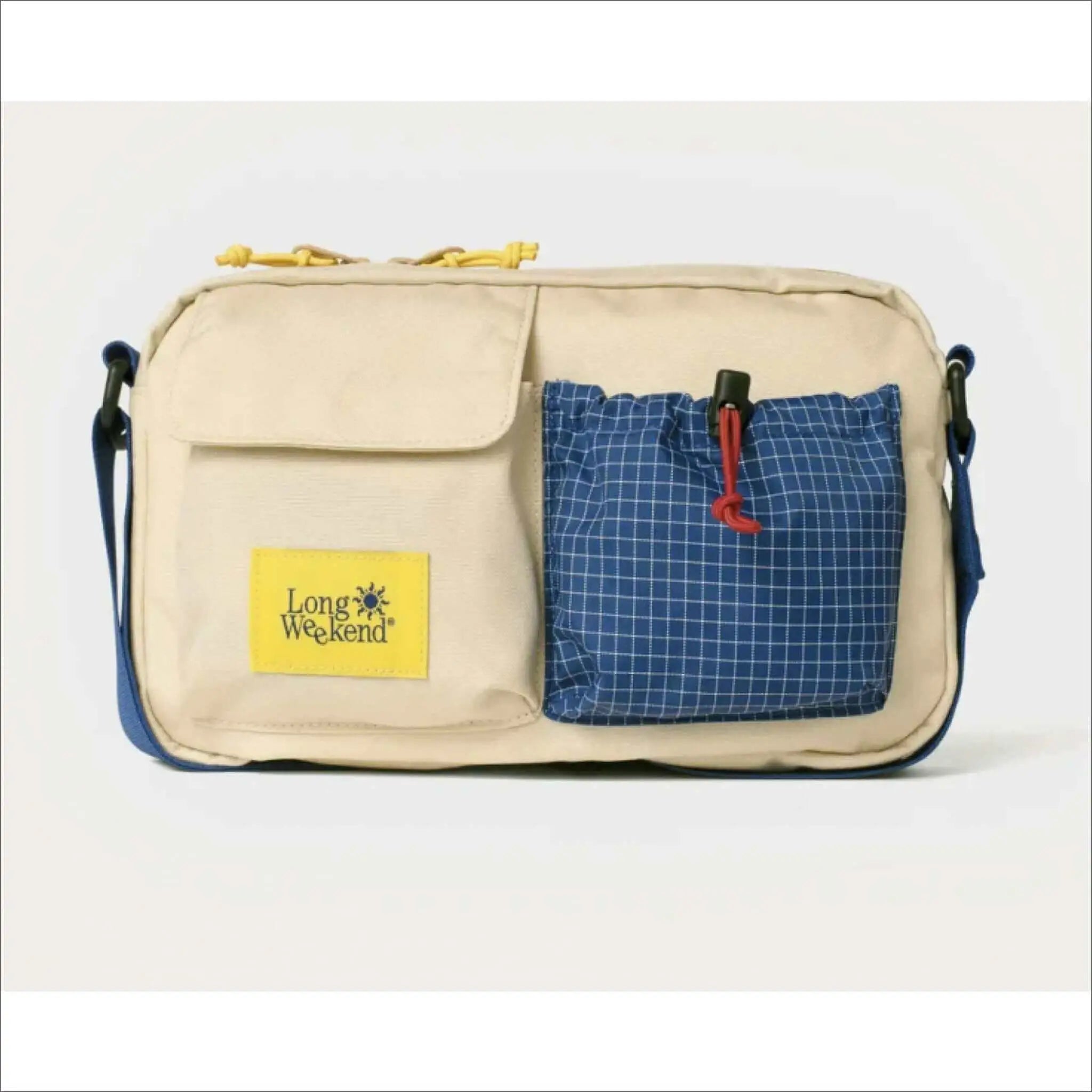 Beige and blue long weekend crossbody bag with a yellow logo patch, checkered pocket, and adjustable strap.