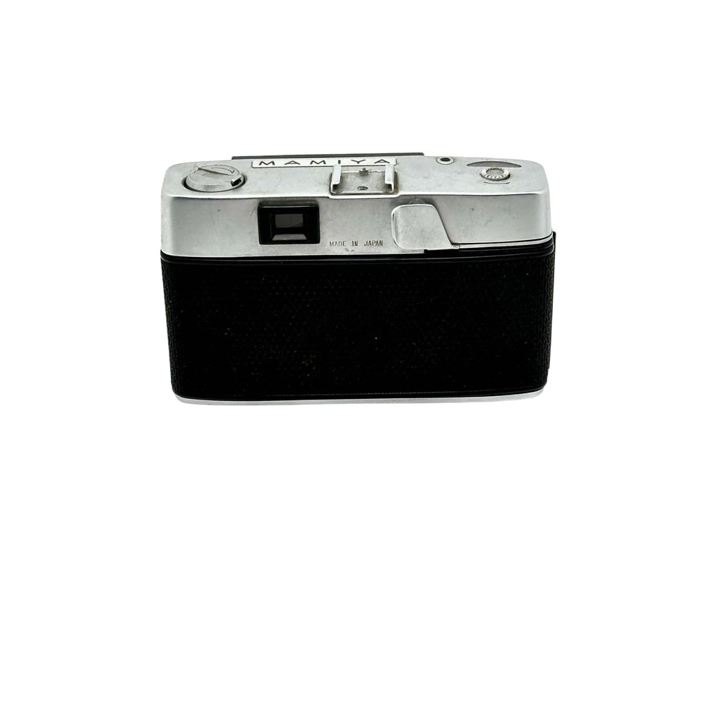 Silver-bodied mamiya film camera with a black textured leather grip.