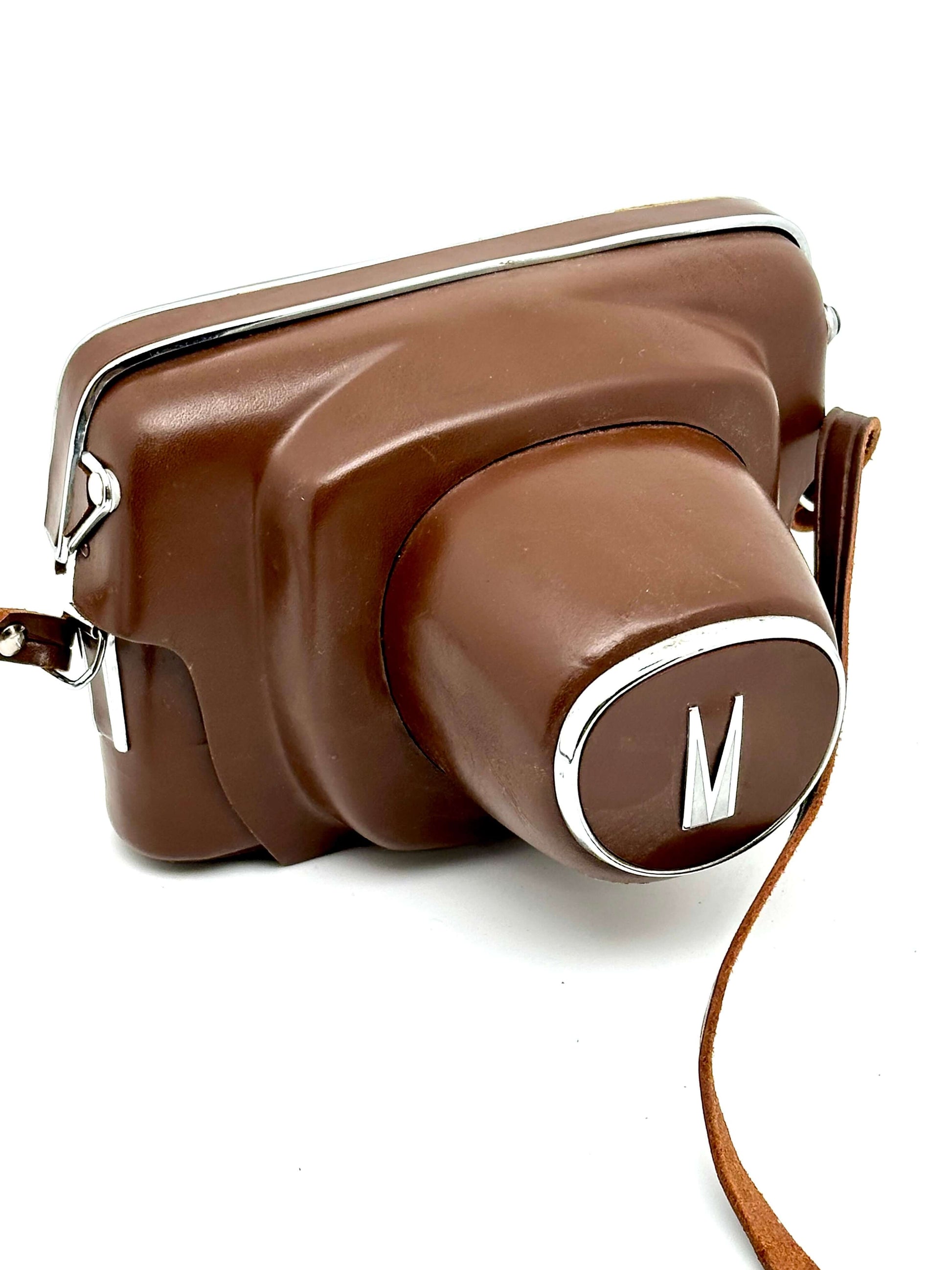 Mamiya Prismat NP vintage 35mm film camera in brown leather case with strap, showcasing retro design.