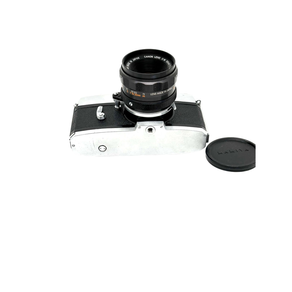 Silver and black canon camera body with a matching lens mounted on top.