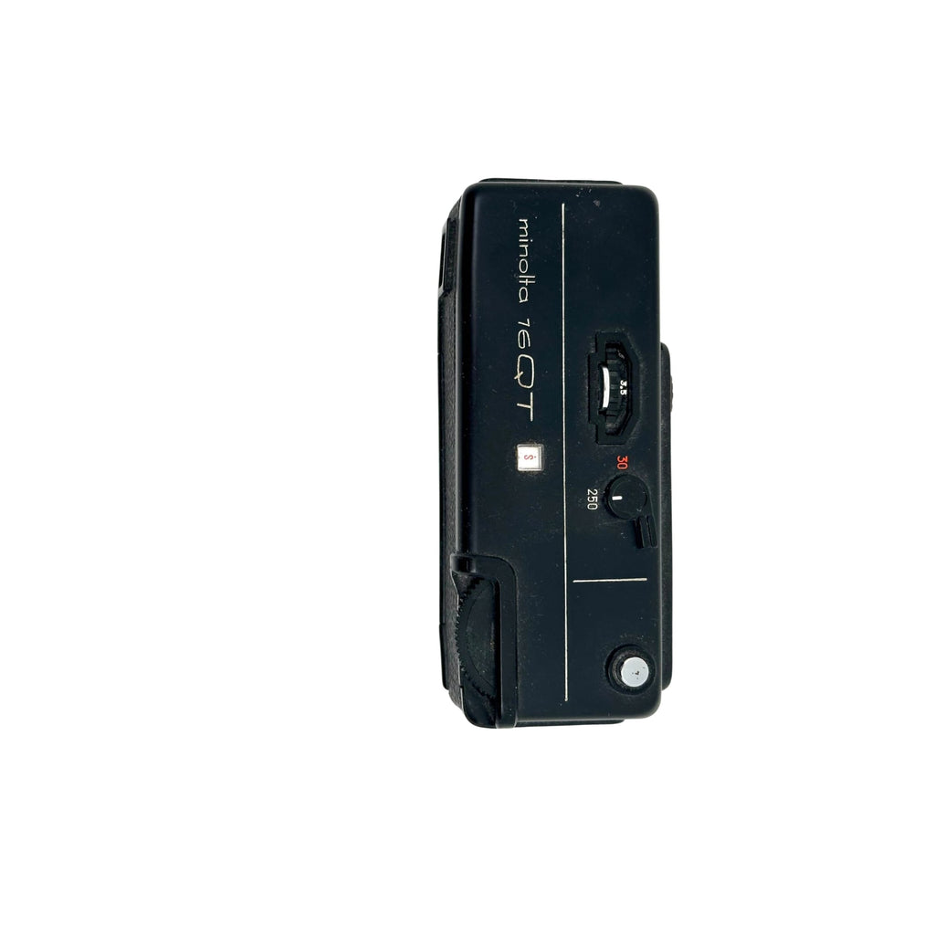 Black minolta 7eqt film camera with a compact, rectangular body and visible dials for shutter speed settings.