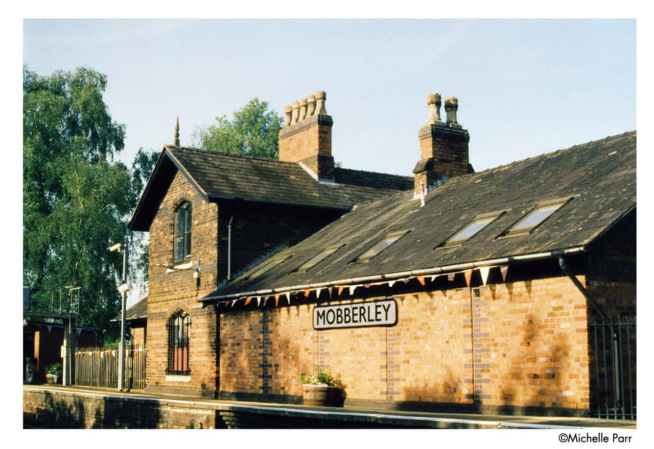 Historic Mobberley train station building with classic architecture and signage.