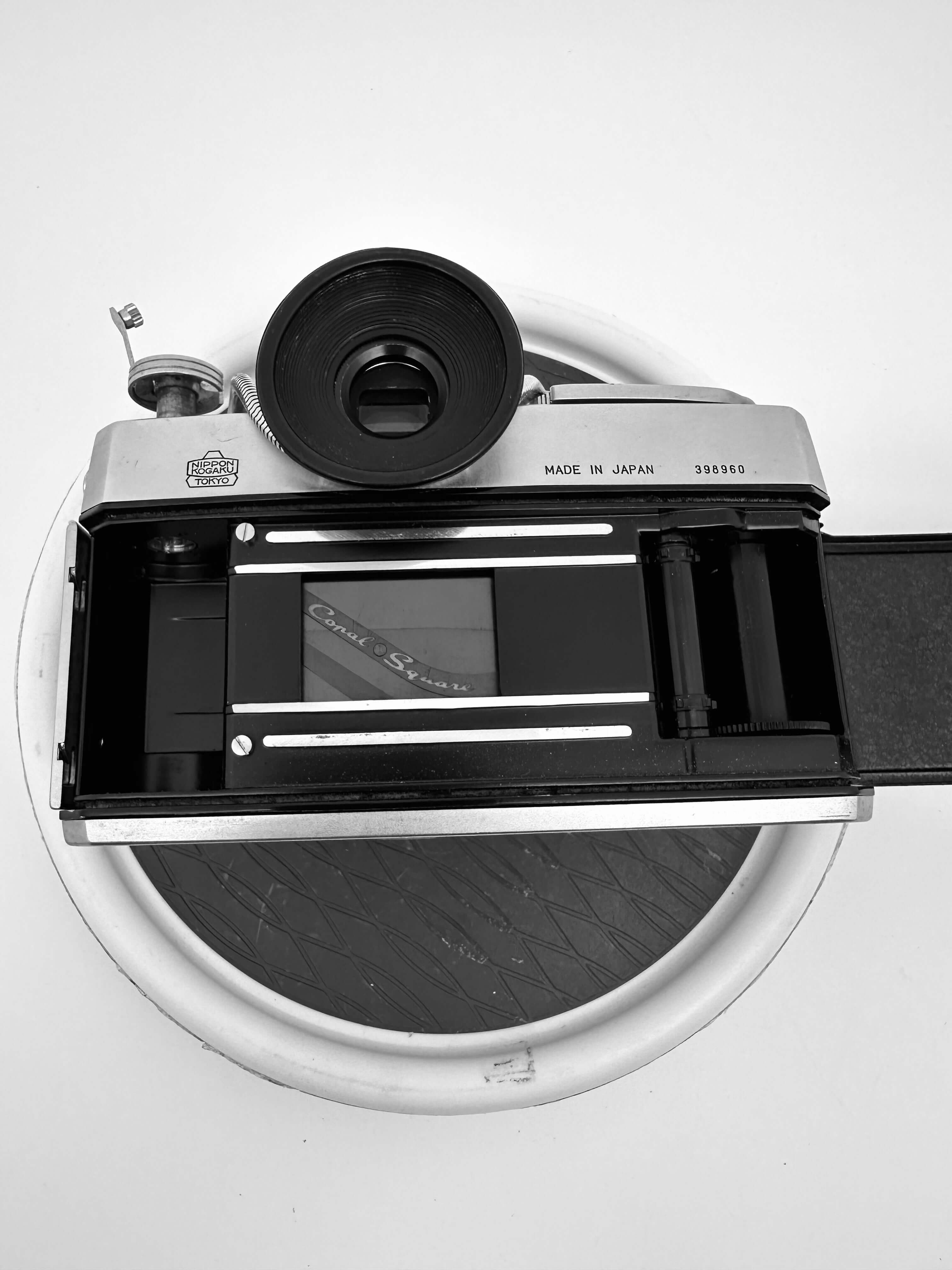 Top view of a vintage Nikkorex F 35mm film camera with open film compartment, showcasing its classic design.