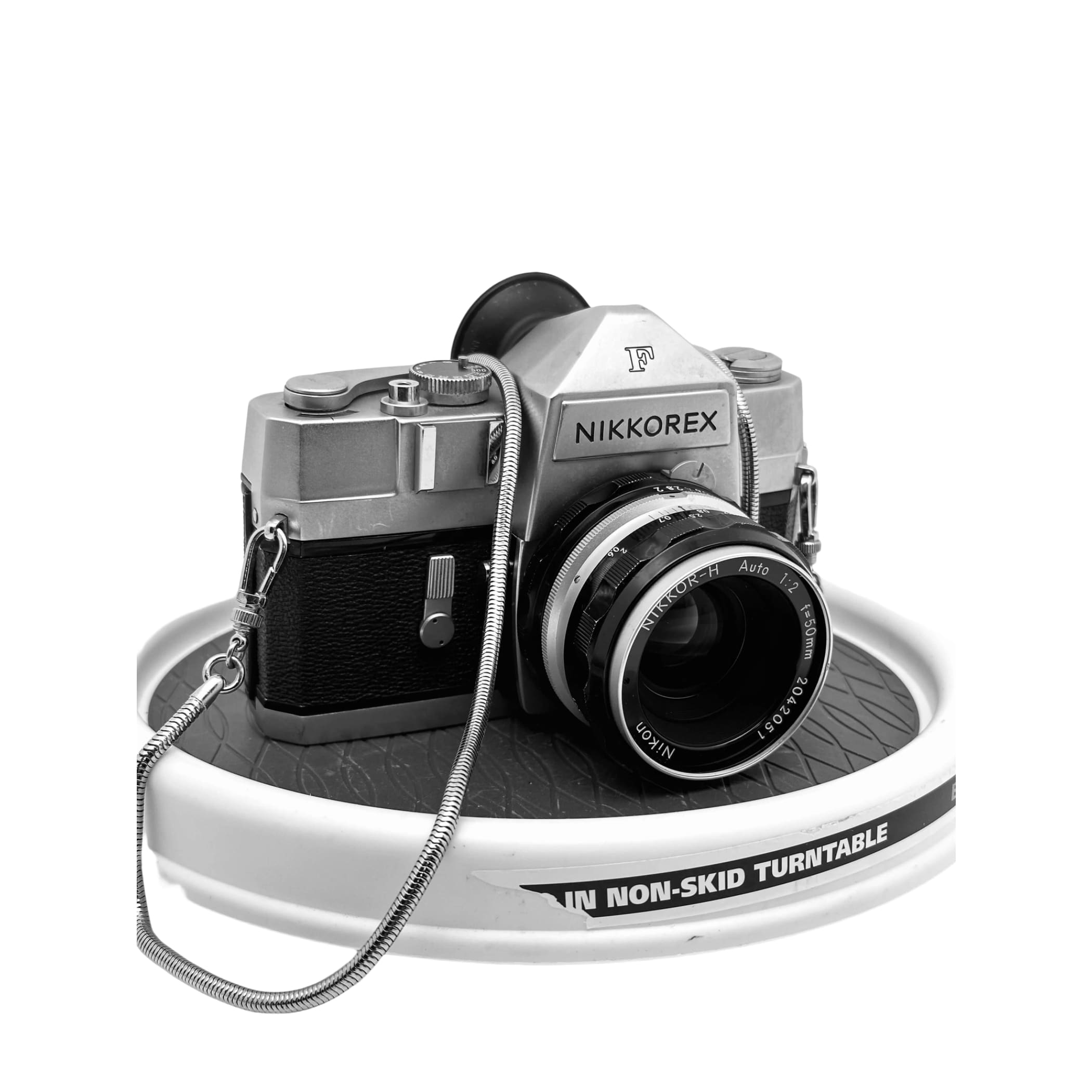 Silver and black nikkorex f camera with a nikkor-h auto 1:2 lens.
