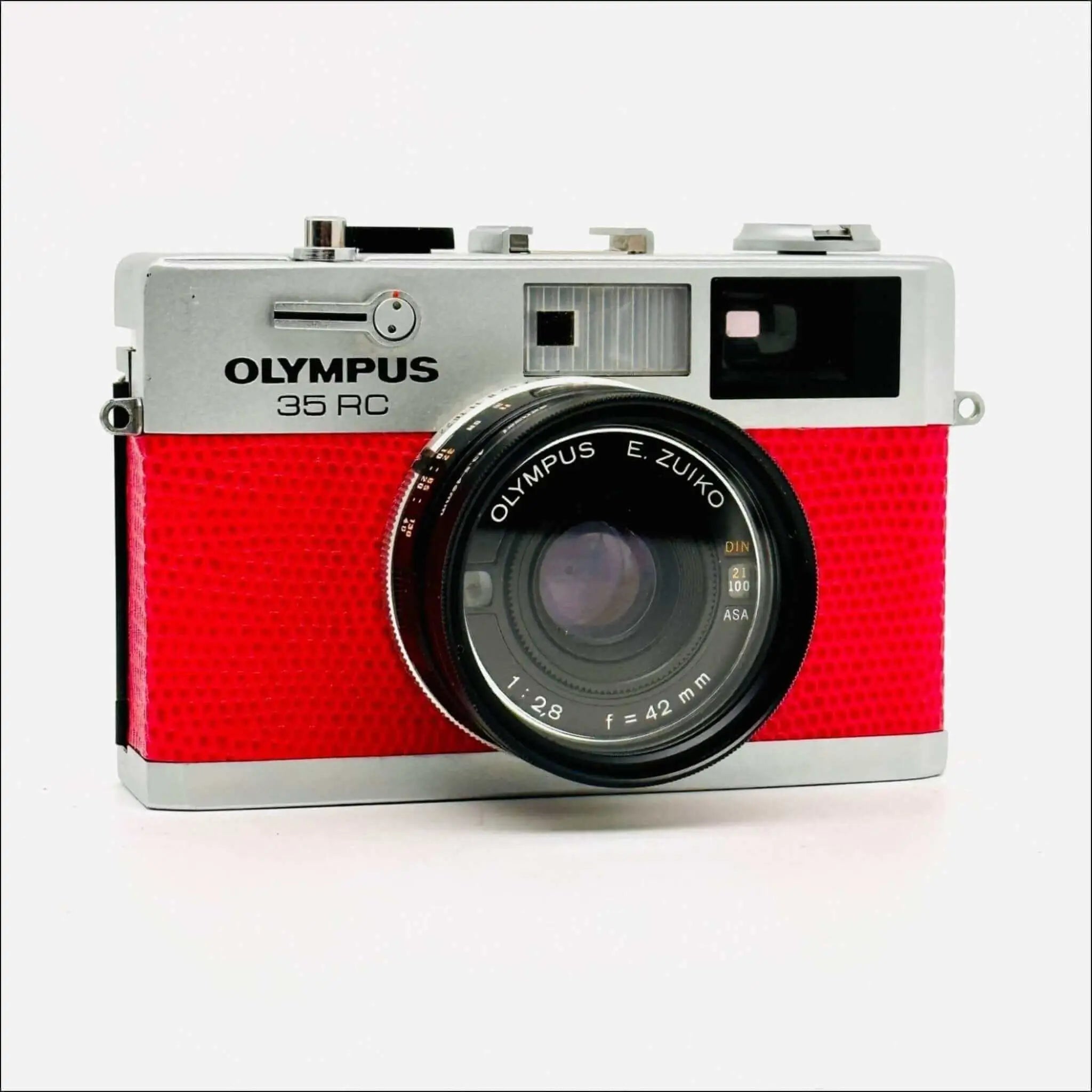 Red textured body with silver top and lens mount, featuring an olympus 35 rc camera equipped with a zuiko 42mm f/1.8 lens.