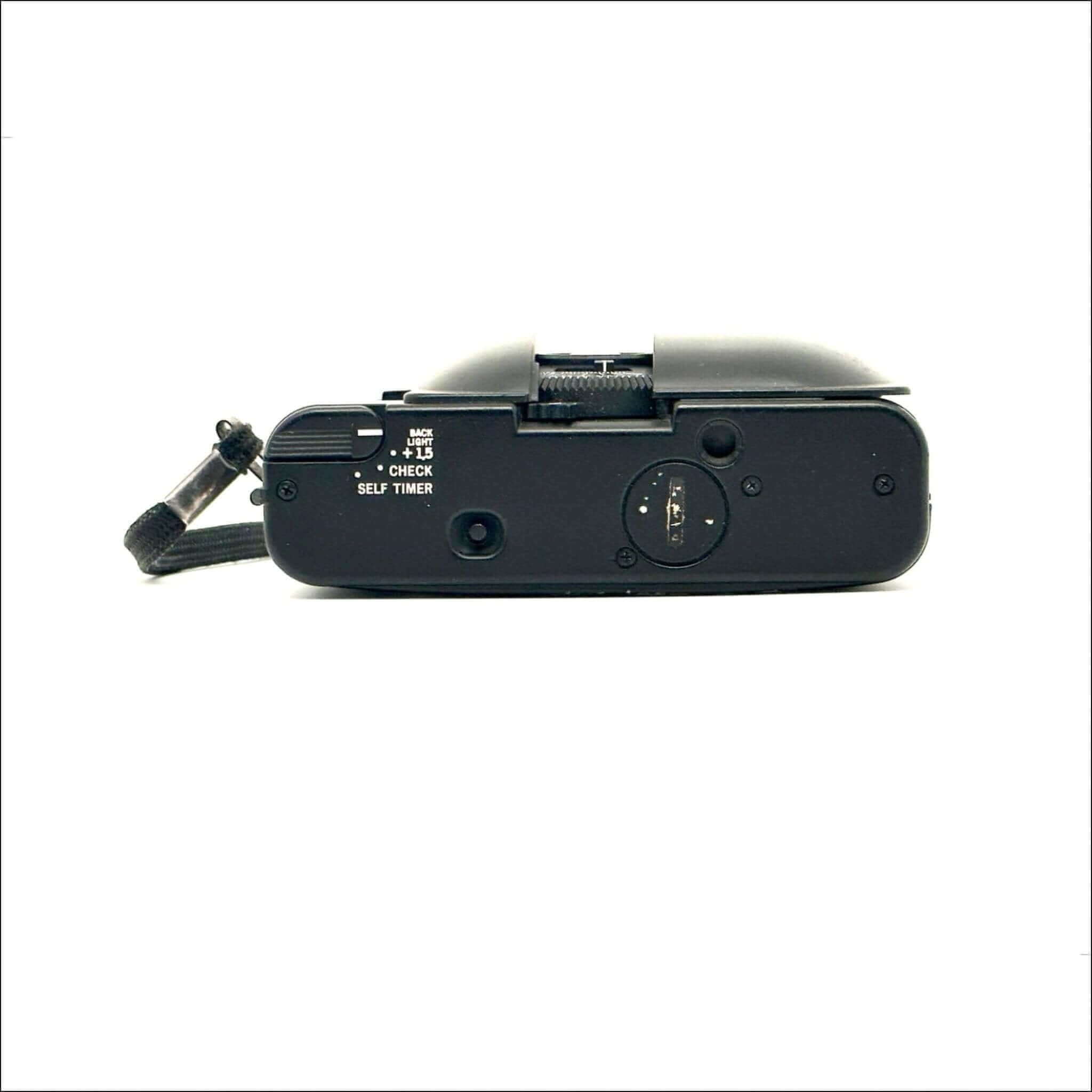 Black fujifilm compact camera with a textured grip and visible control dials.