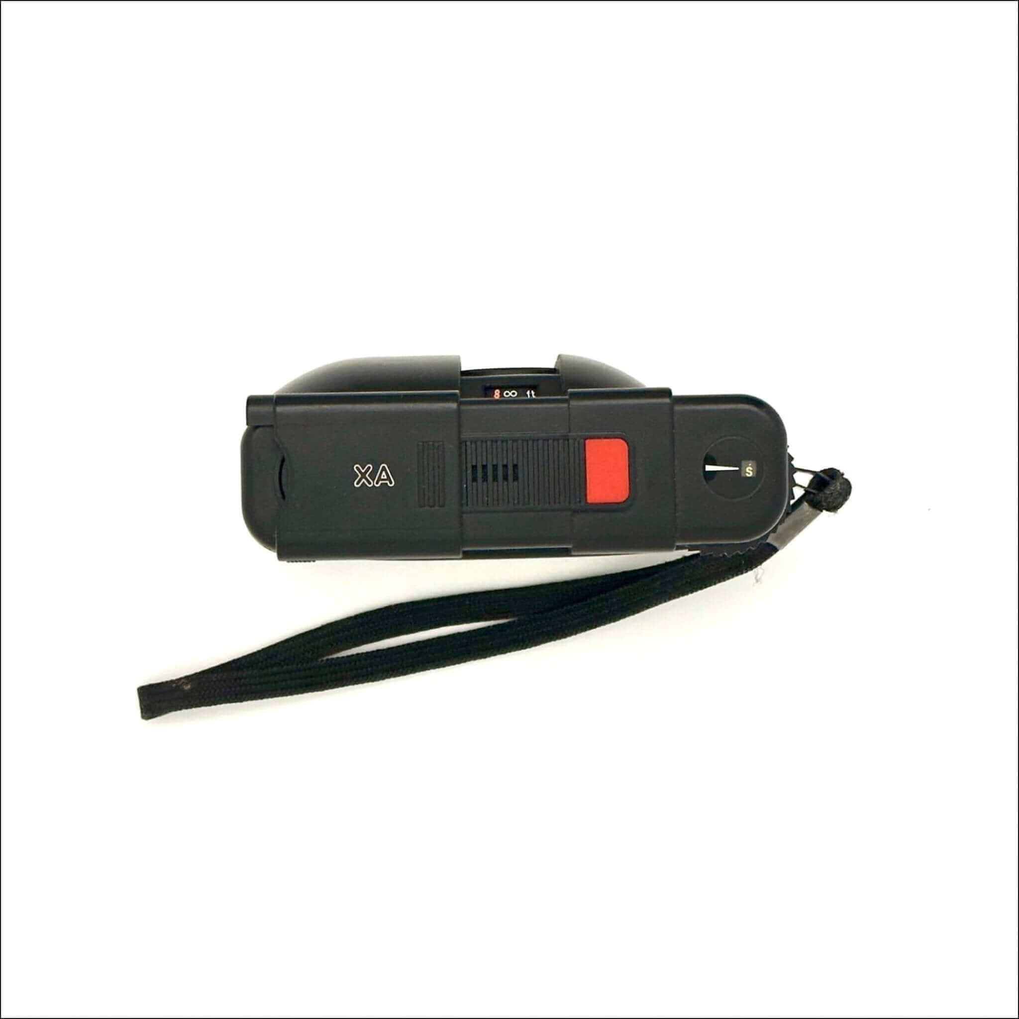 Black plastic stun gun with a red trigger and a black wrist strap.