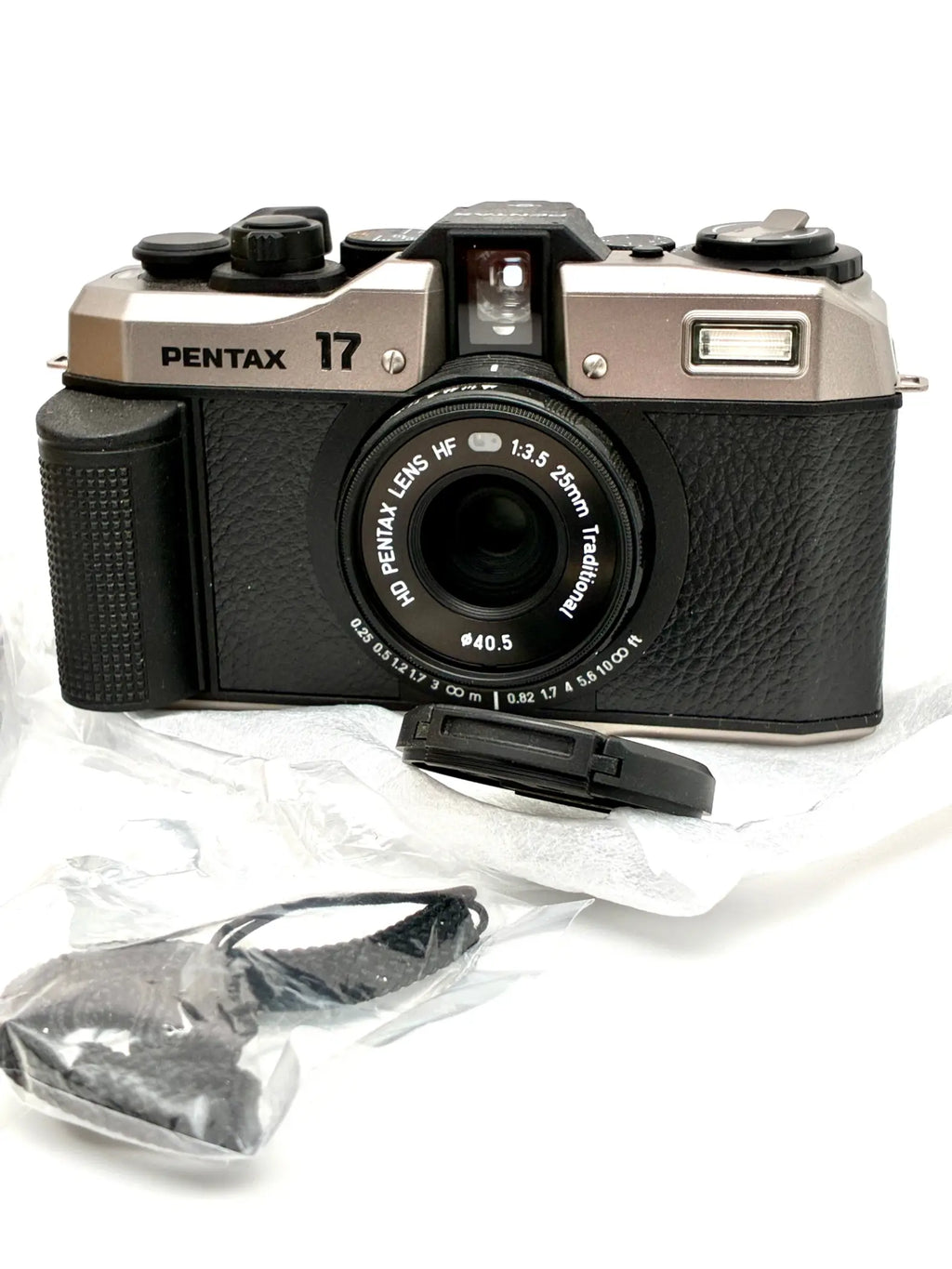 Black and silver pentax 17 35mm half-frame film camera with black leather-textured body and mounted hf 28mm f 3.5 lens
