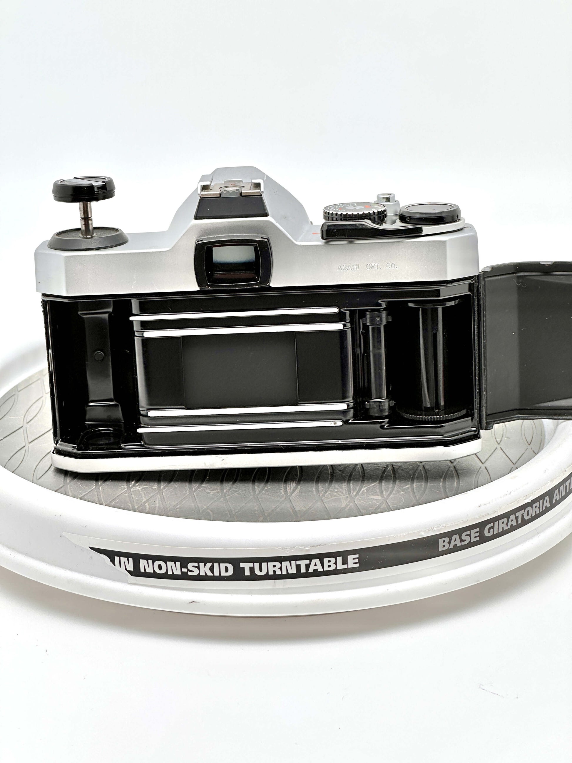 Back view of Japanese Asahi Pentax K1000 black 35mm film camera, revealing film compartment and sturdy design.