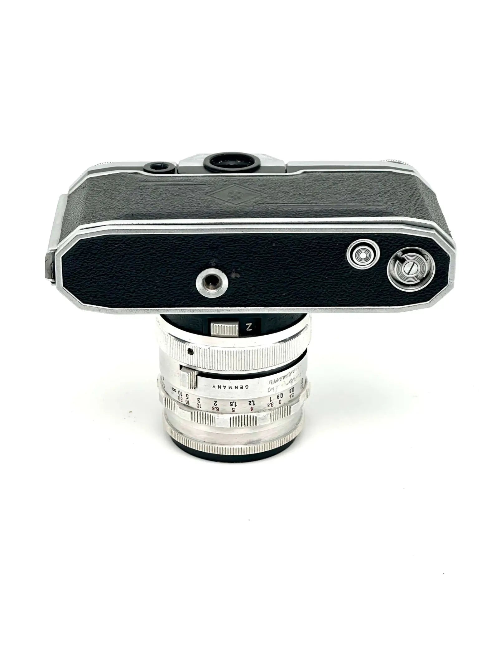 Silver and black leica camera body with a matching silver lens mounted on top.