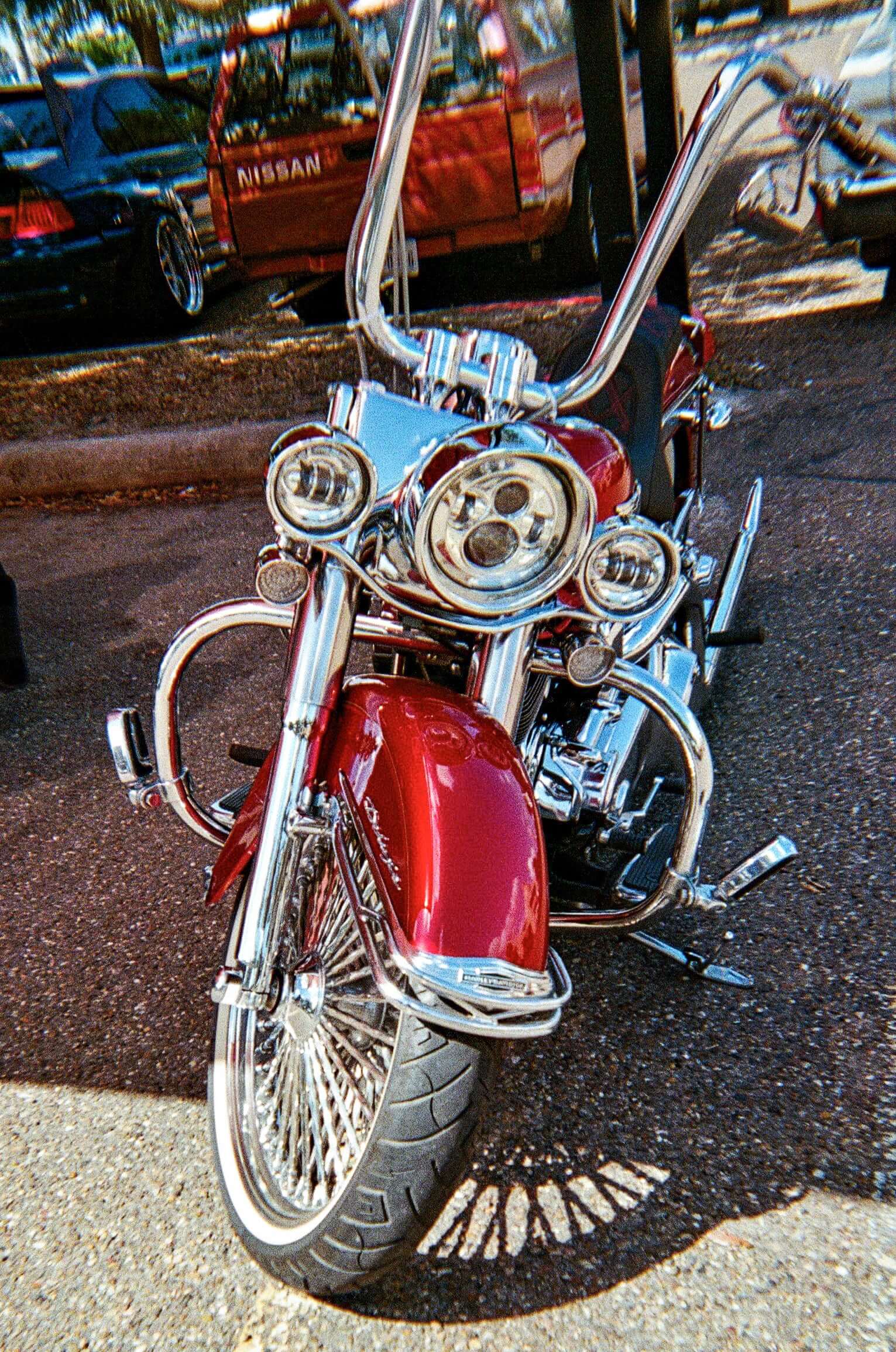 Front view of a classic red motorcycle with chrome detailing, showcasing vintage design and powerful headlights.