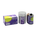 Purple and silver reflex lab 400 daylight 35mm color negative film canister with a partially unspooled roll.