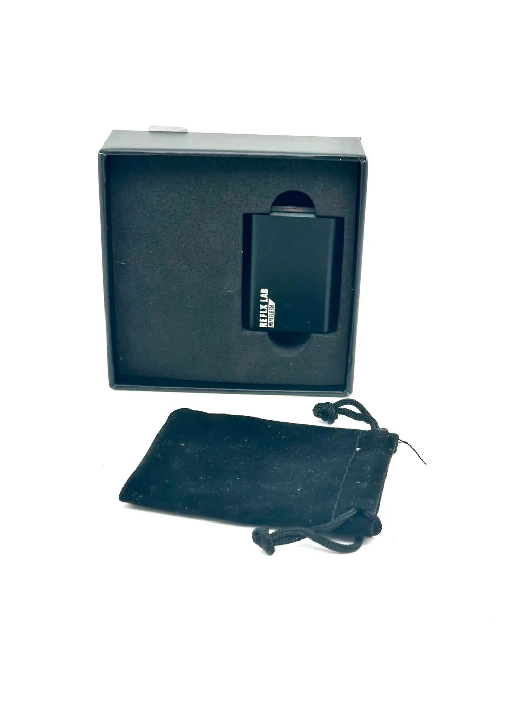 Black rectangular reklab portable charger in sleek matte finish, nestled inside its branded box with a matching velvet pouch.