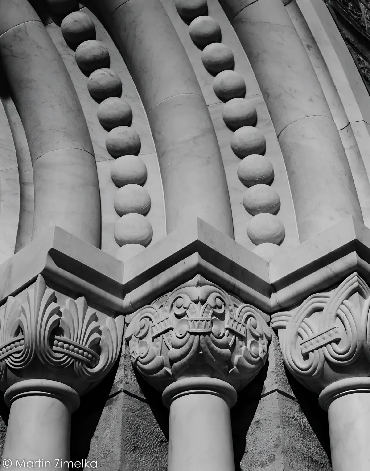 Carved stone columns with ornate capitals and spherical decorative elements.