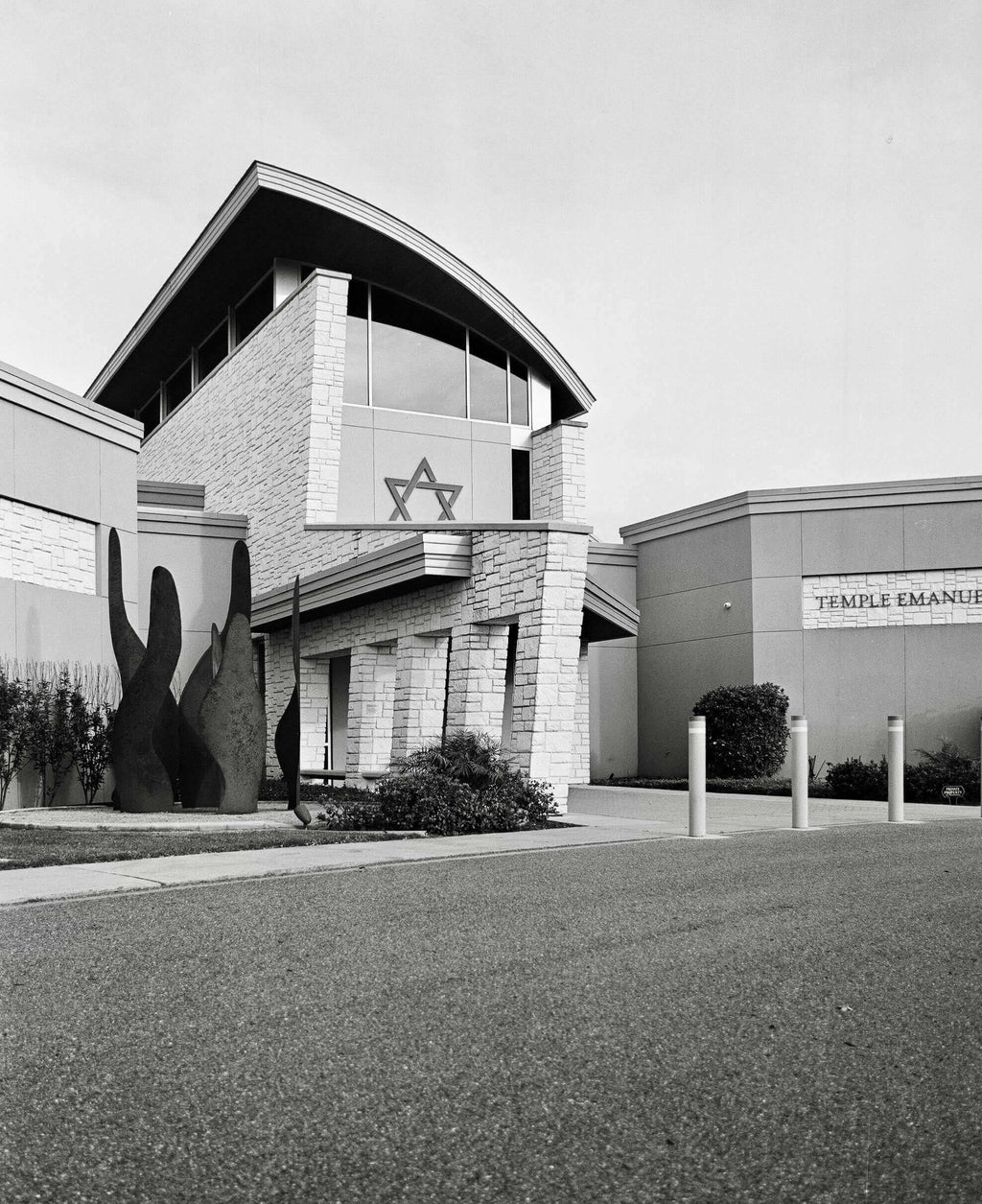 Exterior view of Temple Emanuel building featuring modern architecture and a Star of David symbol in black and white.