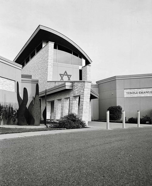 Exterior view of Temple Emanuel building featuring modern architecture and a Star of David symbol in black and white.