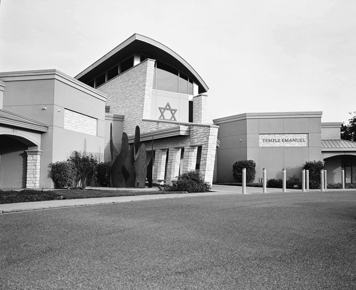 Exterior view of Temple Emanuel featuring modern architecture and a Star of David in black and white.