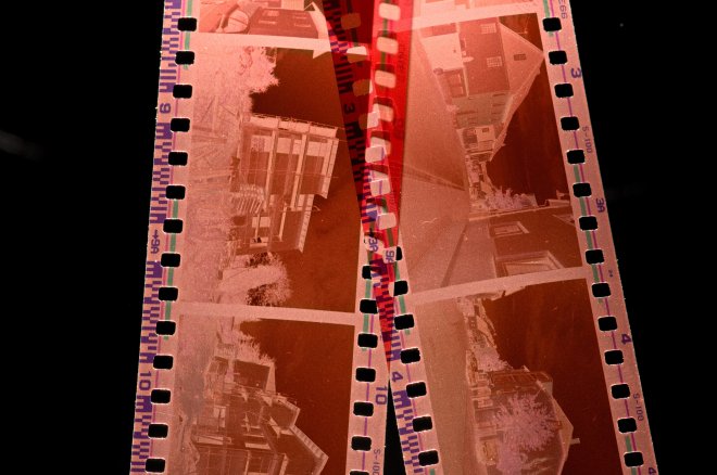 Two reddish-brown photo printing film strips with perforated edges