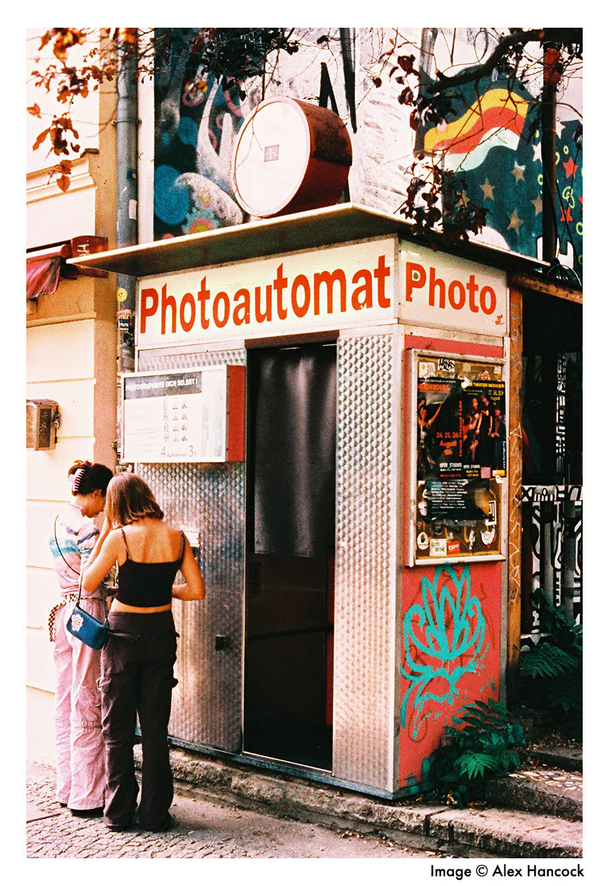 2 gals outside photoautomat booth photographed by alex hancock on harman phoenix 200 35mm film