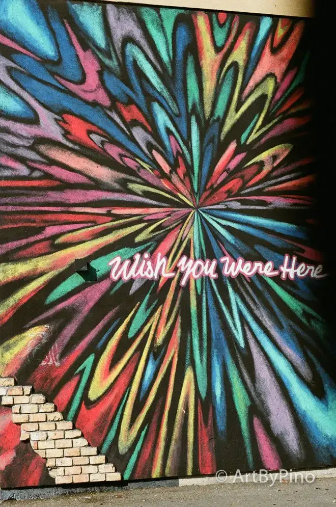 Vibrant psychedelic mural in Texas view fullsize with rainbow swirls and wish you were here text