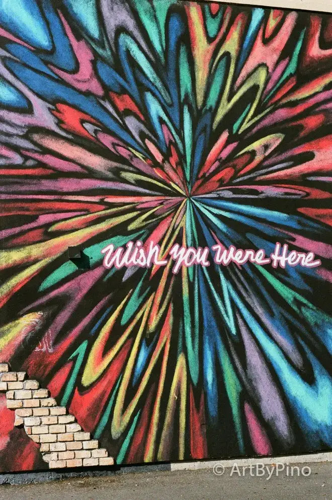 Vibrant psychedelic mural in Texas view fullsize with rainbow swirls and wish you were here script