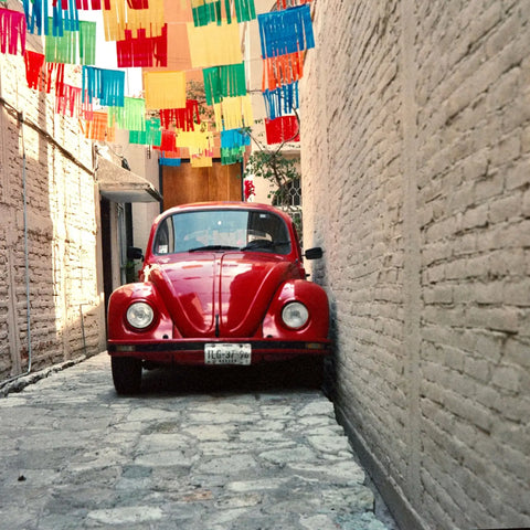 Red classic Volkswagen Beetle in alleyway, shot on Kodak Vision3 film
