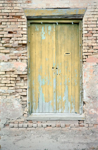 Weathered yellow door in Kodak Vision3 film style, ECN-2 processed