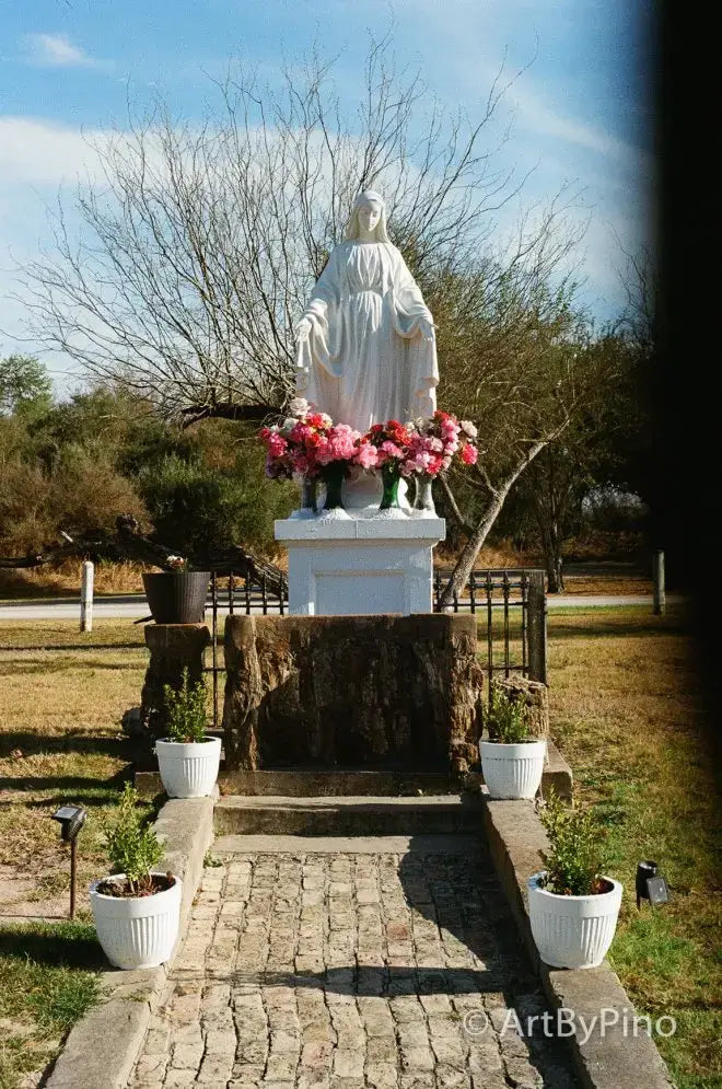 White marble Virgin Mary statue with pink red flowers in green vases, texas view fullsize