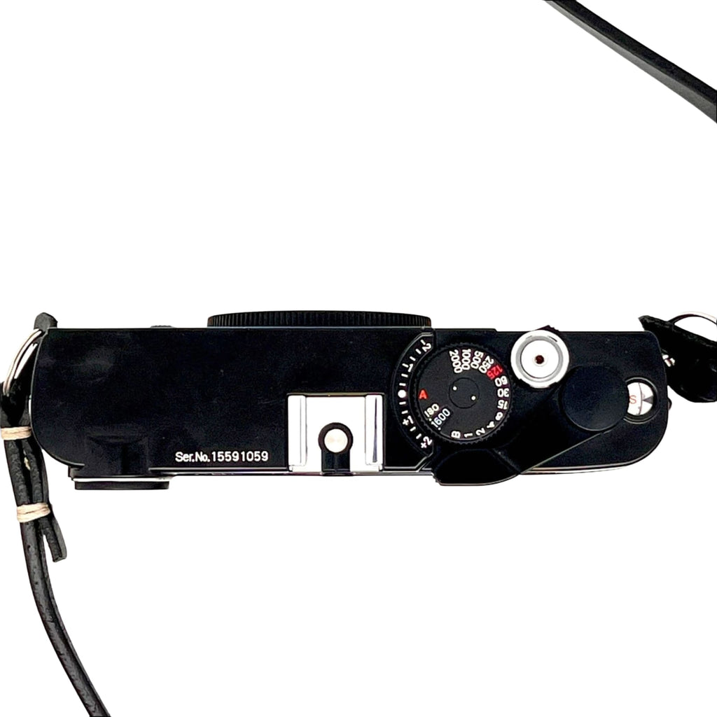 Black leica m10 film camera with a silver shutter speed dial and black leather strap.