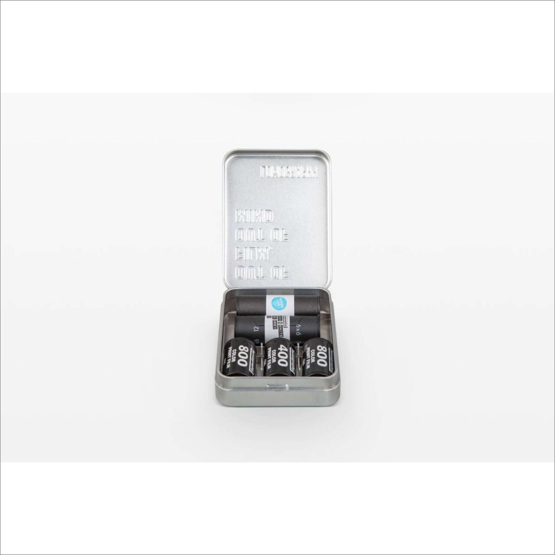 Lomography metal film case tin opened, holding 35mm and 120 film rolls organized and protected.