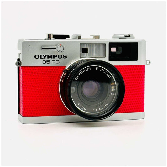Olympus 35 RC 35mm used pink rangefinder film camera with E. Zuiko lens and retro design.