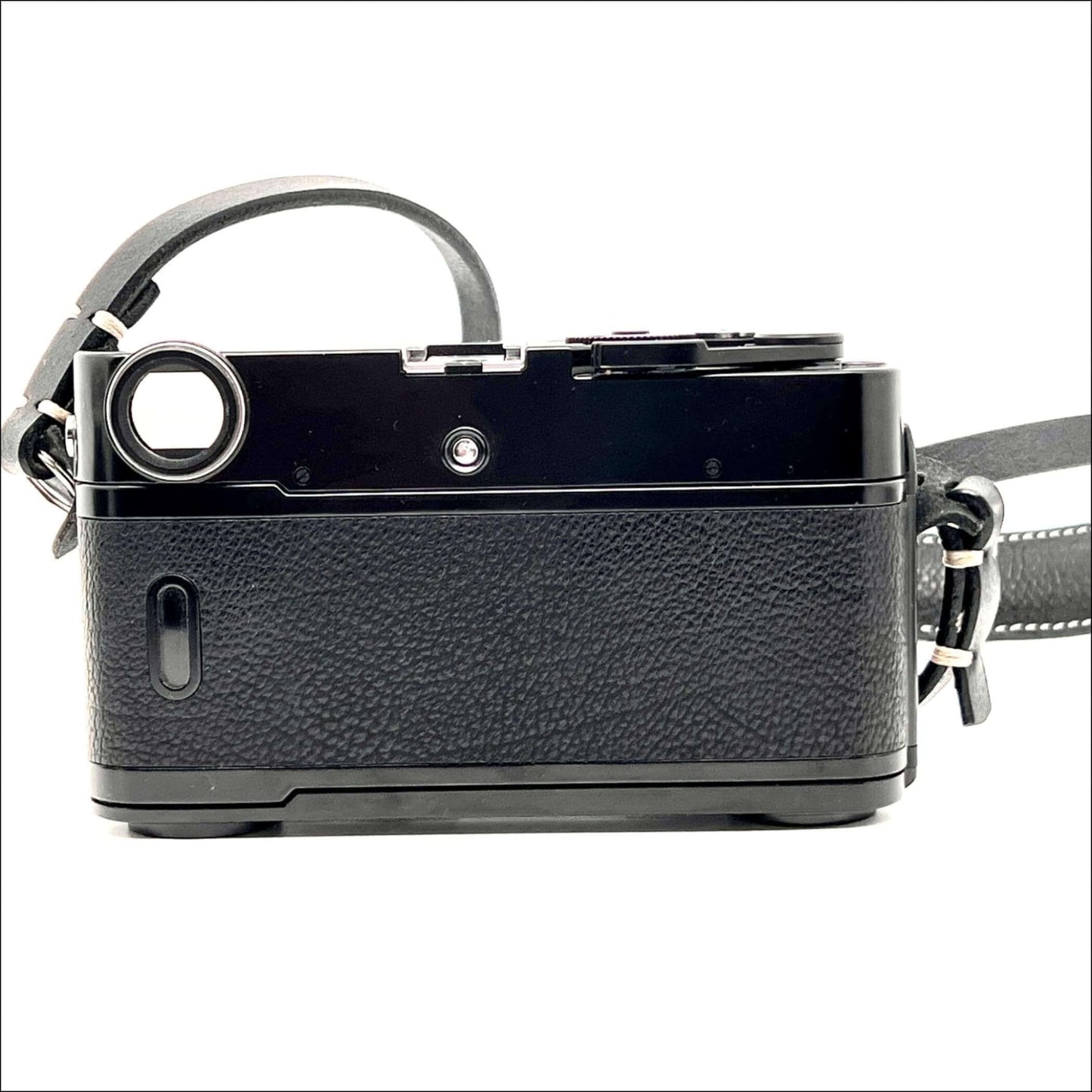 Side view of used Zeiss Ikon ZM 35mm film camera body in black with textured finish and strap.